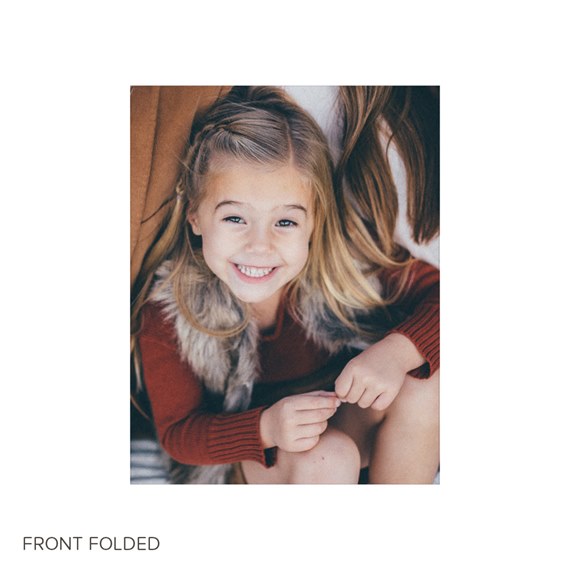 Close-up portrait of a smiling young girl in a red sweater and fur vest