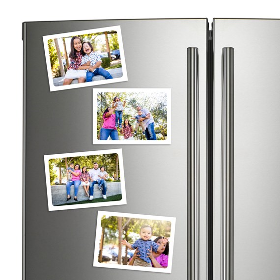 set of four photo magnets with white borders on a fridge