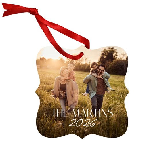 scalloped metal ornament with photo area and red ribbon