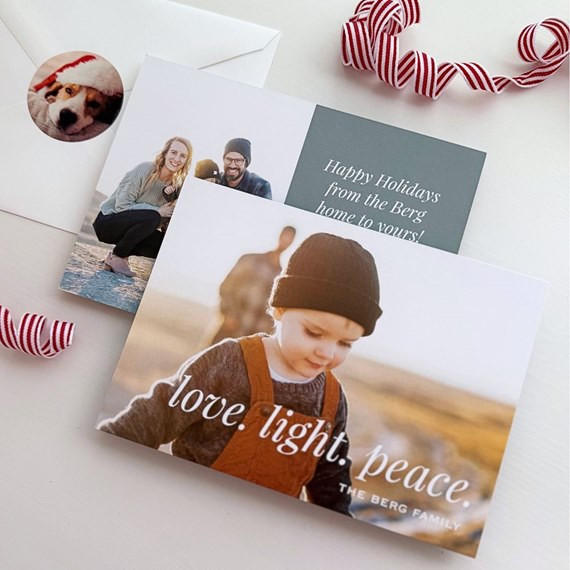 Holiday photo card showing a child in a beanie and overalls with the words 