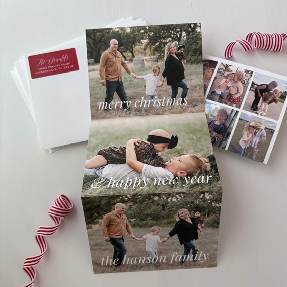 folded A6 holiday photo card with family pictures and white script seasonal greetings