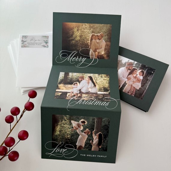 dark green folded Christmas photo card with three family photos and white calligraphy greeting