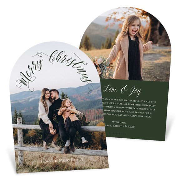 Arched Christmas photo card with curved 'Merry Christmas' calligraphy over a family photo and a reverse side showing a child's photo with a dark green message panel reading 'Love & Joy'.