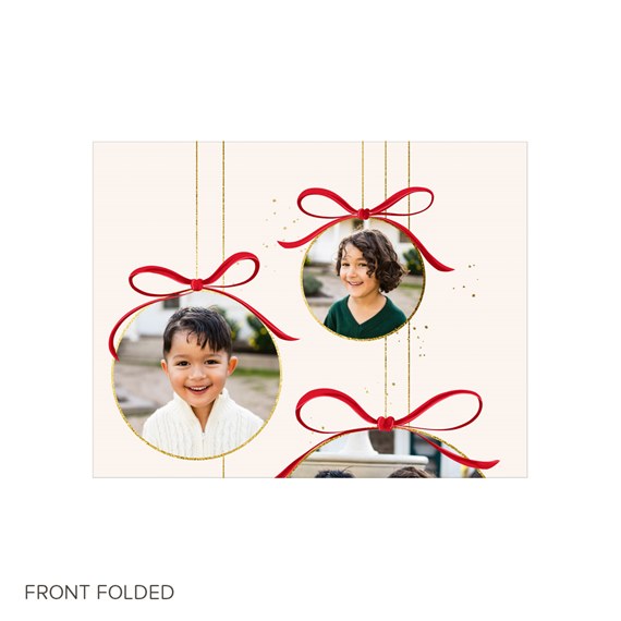 Folded Christmas card with three photo ornaments, red bows and gold trim on beige background