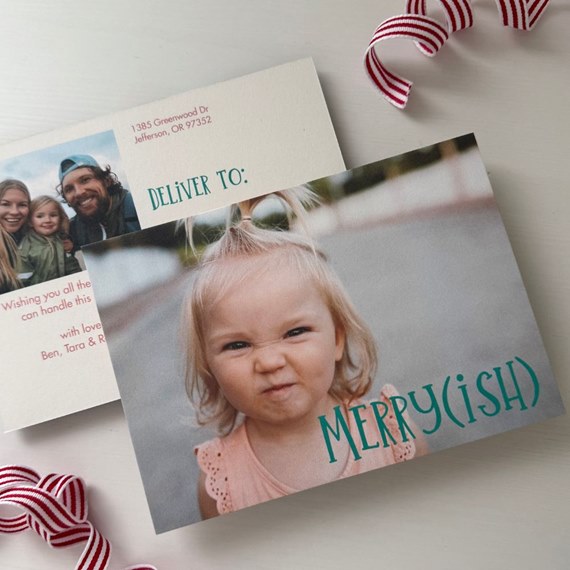 Holiday photo postcard with toddler making a scrunched face and teal 