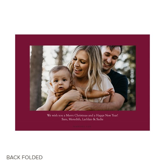 Folded Christmas photo card with burgundy border, family portrait photo and printed holiday greeting