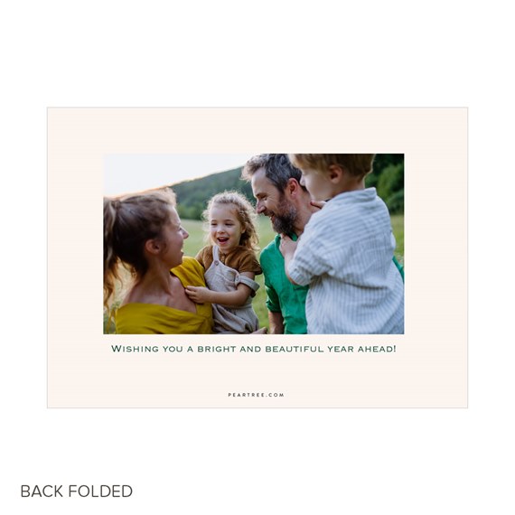 Folded holiday photo card with family portrait in a rectangular collage, cream border and centered greeting text beneath the image.