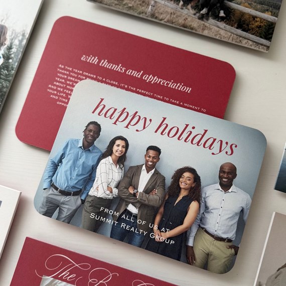 Holiday photo card with five-person team and red "happy holidays" text on a pale blue background