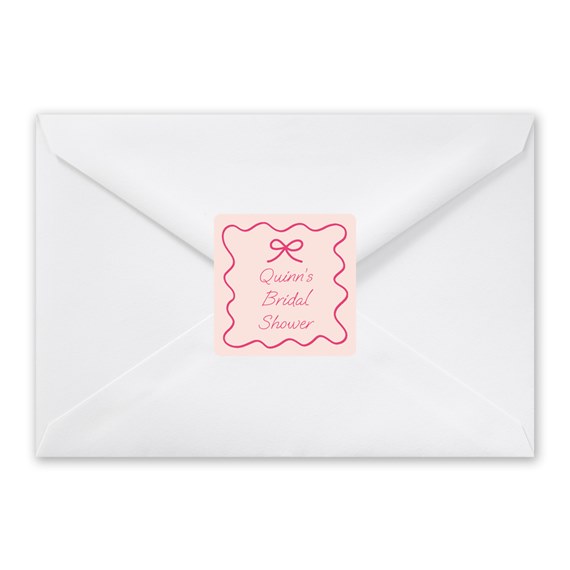 white envelope with pink scalloped sticker and decorative text