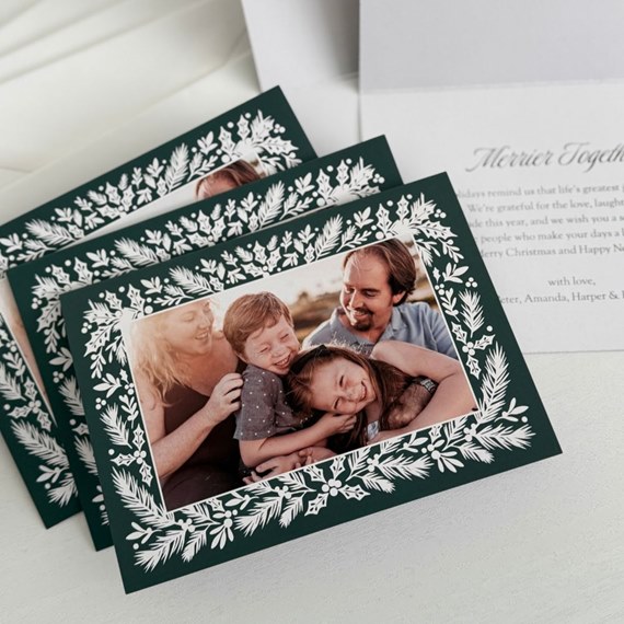 Christmas card with greenery border and photo area