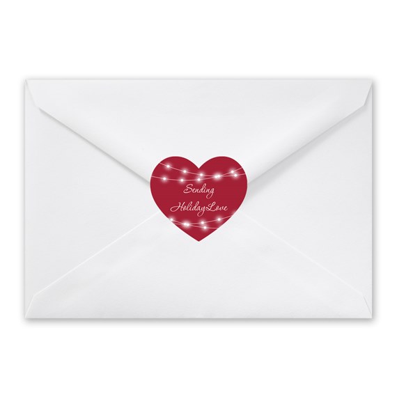 white envelope with red heart seal and string lights