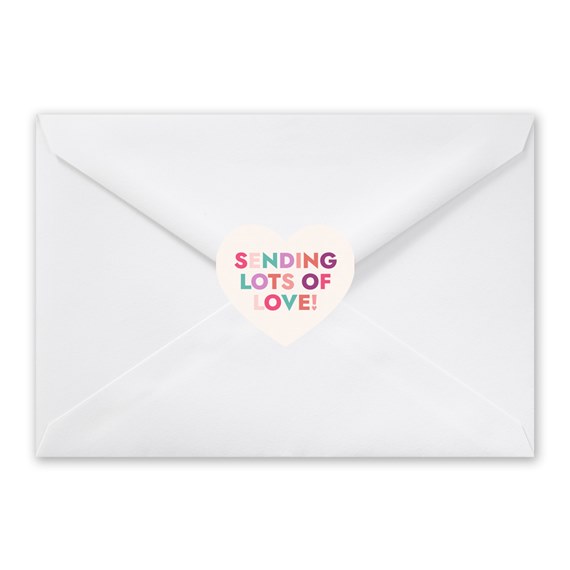 white envelope with heart-shaped seal and colorful text