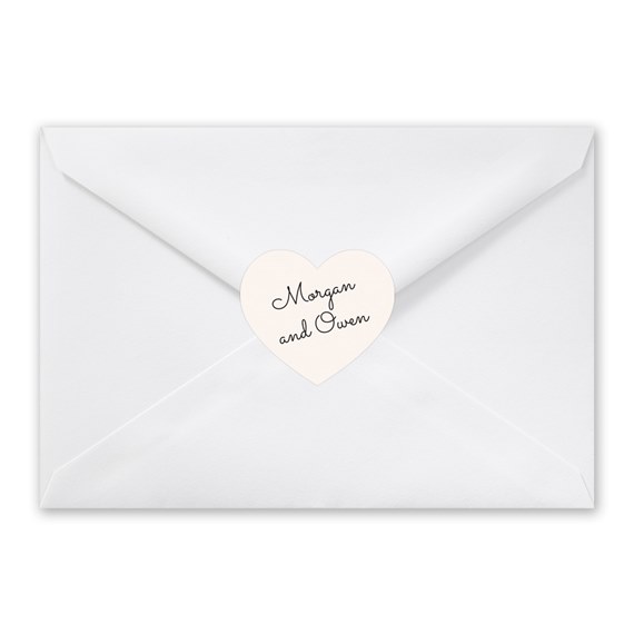 white envelope with heart-shaped seal and cursive text